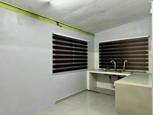 La salle de bains est pourvue d'un lavabo et de 2 fenêtres. dans l'établissement Teratak Tok Ma Rumah Cengal, à Kuala Terengganu