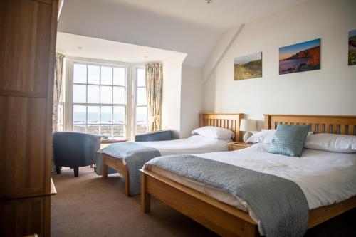 a hotel room with two beds and a window at Hartland Quay Hotel in Hartland
