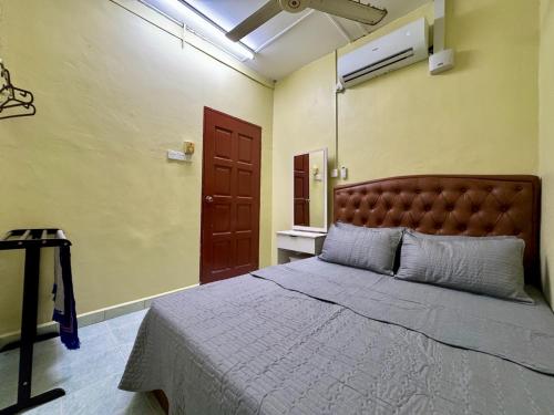 - une chambre avec un lit doté d'une tête de lit marron et d'une fenêtre dans l'établissement Teratak Tok Ma Rumah Cengal, à Kuala Terengganu