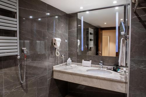 a bathroom with a sink and a mirror at Grand Aras Hotel & Suites in Istanbul