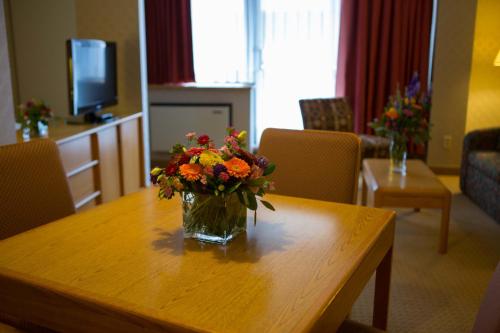 a vase of flowers sitting on a wooden table at Cartier Place Suite Hotel in Ottawa