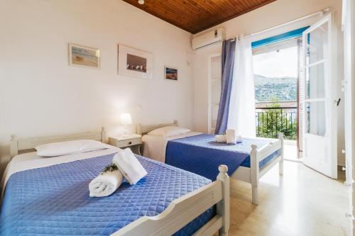 een slaapkamer met 2 bedden en een raam bij Sunflower Apartments & Studios in Kassiopi