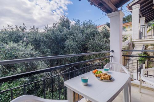 a table with a bowl of fruit on a balcony at Sunflower Apartments & Studios in Kassiopi