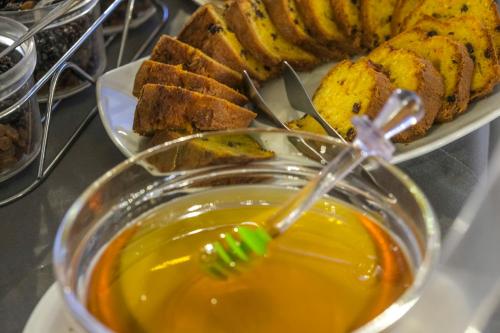 a bowl of honey next to a plate of bread at Lotus Inn in Athens