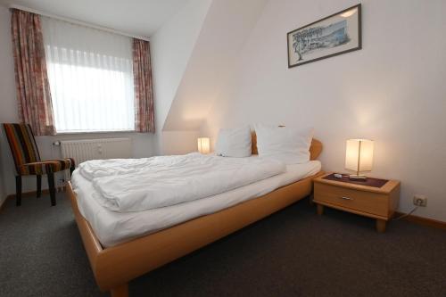 um quarto com uma cama e uma mesa com 2 candeeiros em Bernstein Mare-Comfort Wohnung 7 em Büsum