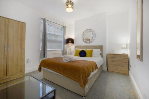 a bedroom with a bed and a glass table at Elegant 4 Bedroom Near South Park Sleeps 7 in Darlington