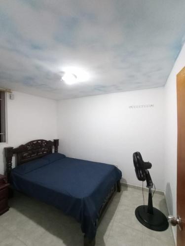 Un dormitorio con una cama y una lámpara. en Habitación doble cómoda en Valledupar