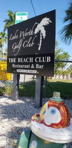 a sign for the beach club with a fire hydrant at Life's a Beach in Lake Worth