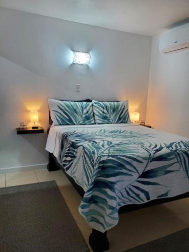 um quarto com uma cama com um edredão azul e branco em the Blue Ackee em Montego Bay