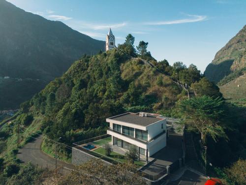 a house on a hill with a clock tower on it at Villa Montana in São Vicente