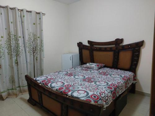 Schlafzimmer mit einem Bett mit einer roten und weißen Decke in der Unterkunft TWO BEDROOM VACATION HOME AT SHARJAH DUBAI BOARDER BY MAUON.COM in Schardscha