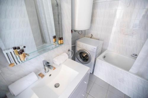 La salle de bains blanche est pourvue d'un lavabo et d'un lave-linge. dans l'établissement Very Nice View by Connexion, à Cannes