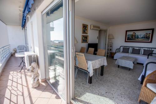 d'un salon avec une table et un balcon. dans l'établissement Very Nice View by Connexion, à Cannes