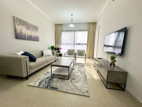 a living room with a couch and a tv at Luxury waterview 2BD in Sharjah