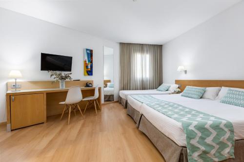 a hotel room with two beds and a desk at Daniya Alicante in Alicante