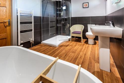 a bathroom with a sink and a tub and a shower at Monamore Guest House in Lamlash