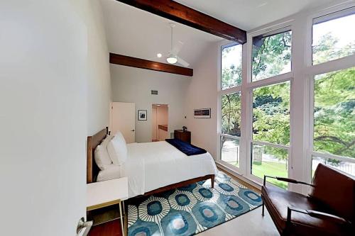 ein Schlafzimmer mit einem Bett und einem großen Fenster in der Unterkunft Beautiful Mid-Century Modern Lakehouse in Austin