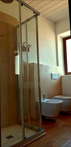 a bathroom with a glass shower and a toilet at B&B EcoAntico casa in paglia in Maiolo