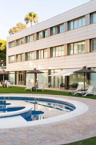 a building with a swimming pool in front of a building at Daniya Alicante in Alicante