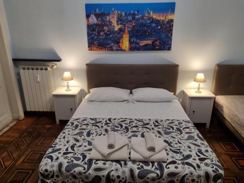 Un dormitorio con una cama con dos zapatos blancos. en Albergo Locanda Alambra, en Génova