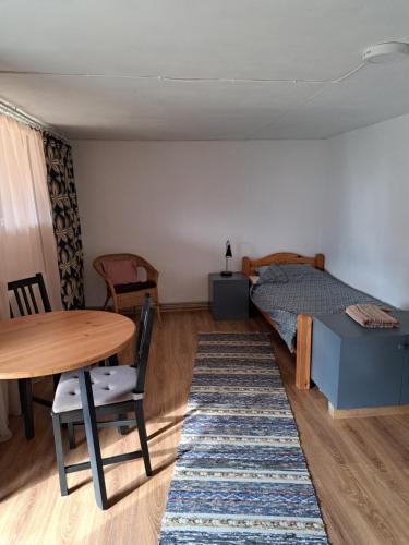 Lejas dzīvoklis Beči في Vecumnieki: غرفة نوم بسرير وطاولة وكراسي