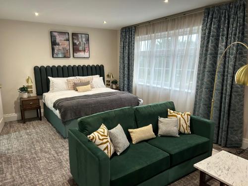 a bedroom with a bed and a green couch at The Hillbrook, Sherborne in Sherborne