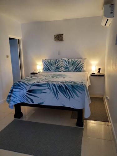 a bedroom with a bed with blue sheets and pillows at the Blue Ackee in Montego Bay