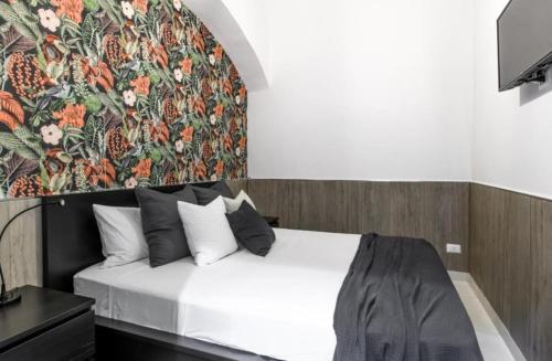 ein Schlafzimmer mit einem Bett mit Blumenwand in der Unterkunft Napuletanata in Neapel