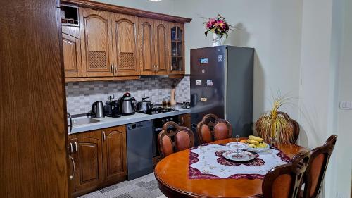 ベラトにあるGuest House Edisonのテーブルと冷蔵庫のあるキッチン