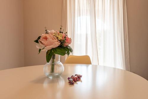a vase with pink flowers sitting on a table at Casa Bianca Bruino, privacy e confort in Bruino