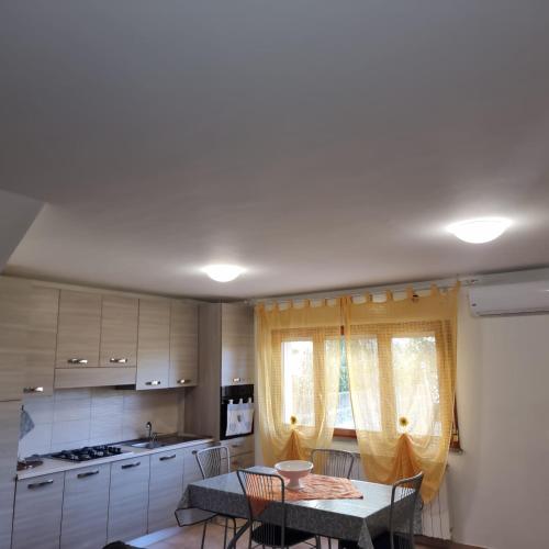 a kitchen with a table and chairs in a room at Appartamento con Giardino, a 10 minuti dal Mare "PE" in Spoltore