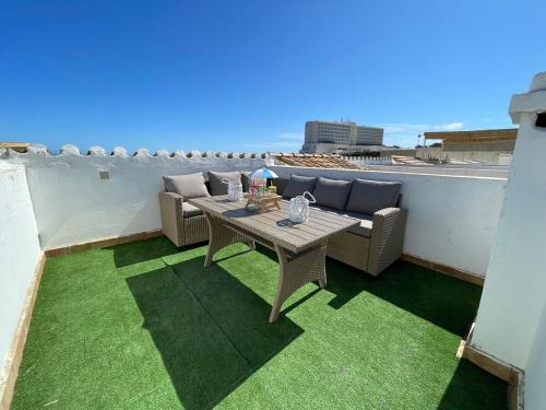 a patio with a table and a couch on a balcony at Apartamento 308 Castell Sol CB in Es Mercadal