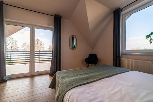 sypialnia z łóżkiem i dużym oknem w obiekcie Dom Przystanek Tałty w mieście Mikołajki