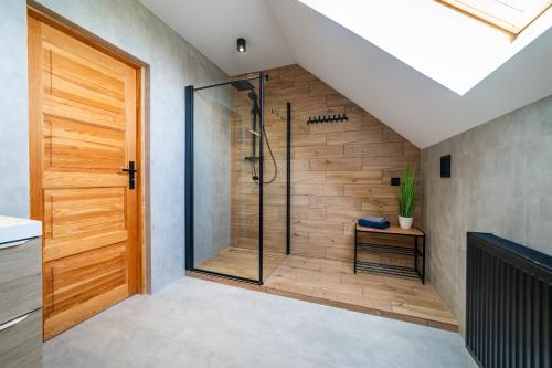 a bathroom with a shower with a glass door at Dom Przystanek Tałty in Mikołajki