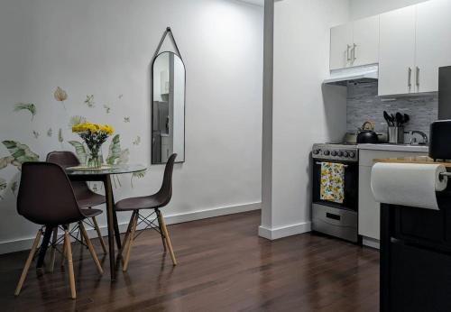 a kitchen with a table and chairs and a kitchen with white cabinets at Modern One Bedroom in Union Sq - great location in New York