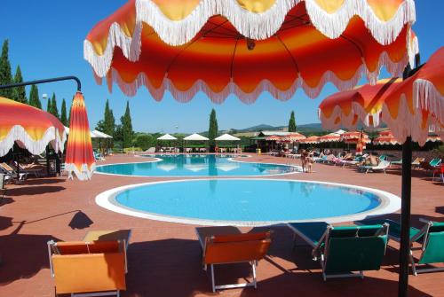 a large swimming pool with chairs and umbrellas at Relais Belvedere in Montecatini Val di Cecina