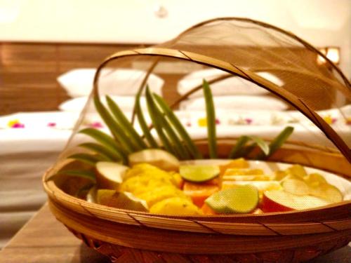 una cesta llena de frutas y hortalizas en una mesa en Akiri Grand, en Thinadhoo