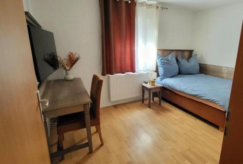 mały pokój z łóżkiem i stołem w obiekcie Gästehaus Da Fabio w mieście Bad Bocklet