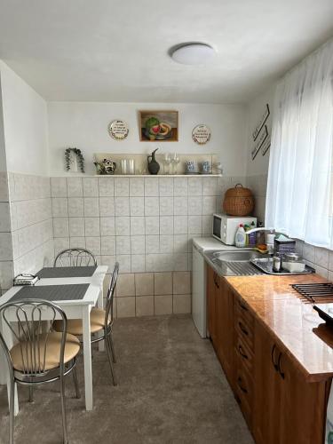 a kitchen with a sink and a table with chairs at Anni in Ventspils