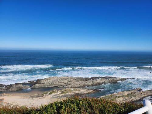 a view of the ocean with rocks and water at Dolly@Skuitbaai in Eersterivierstrand