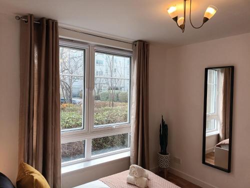 Spacious Elegant 2-BR Apartment in Aberdeen City Centre في أبردين: غرفة نوم مع نافذة كبيرة وسرير