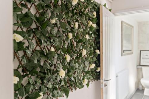 a wall with white roses on a wall at STAYZED N2 - Modern, Colourful NG7 Home, Next To City Centre, Lots Of Amenities, Ideal for Long & Short Stays. in Nottingham