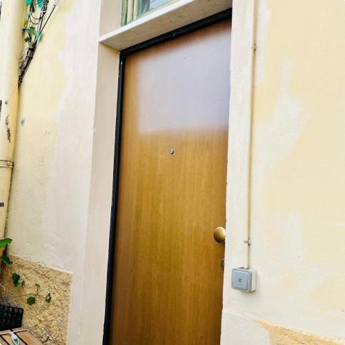 une porte en bois dans un bâtiment à côté d'une fenêtre dans l'établissement Cosy studio - Terrasse ensoleillée - 3 mn Monaco, à Roquebrune-Cap-Martin