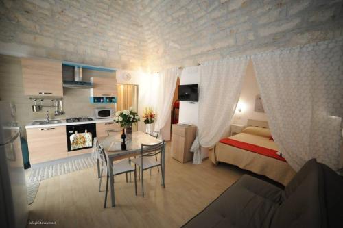 sypialnia z łóżkiem i stołem oraz kuchnia w obiekcie Antica Dimora Giusy w mieście Ostuni