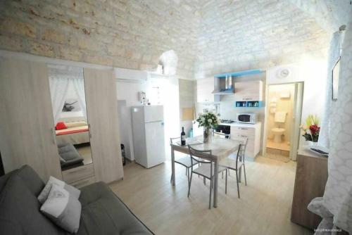 Apartament obejmuje kuchnię oraz salon ze stołem i lodówką. w obiekcie Antica Dimora Giusy w mieście Ostuni