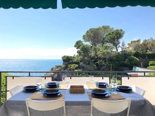 una mesa con sillas blancas y una mesa con el océano en Un Passo dal Mare, en Zoagli