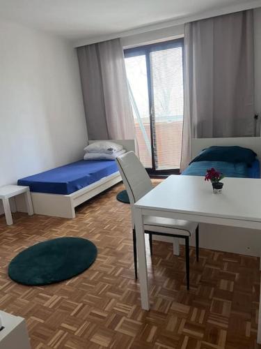 een kamer met een bed, een bureau en een tafel bij Ruhige Wohnung in Schwechat nähe Flughafen in Schwechat