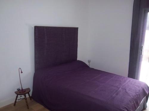 een slaapkamer met een paars bed en een raam bij Gite Jours tranquilles in Pleumeur-Bodou
