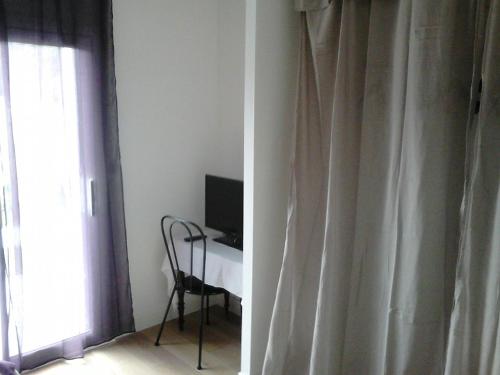 Cette chambre dispose d'une fenêtre, d'un bureau et d'une télévision. dans l'établissement Gite Jours tranquilles, à Pleumeur-Bodou