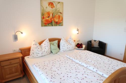 een slaapkamer met een groot bed met witte lakens en kussens bij Rebhof Kaltern in Caldaro
